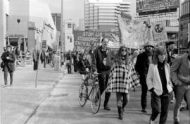 Protesters walking and holding signs in the street. Toronto, 1988.