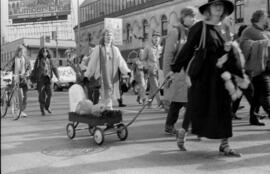 Protester pulling a wagon in the street. Toronto, 1988.