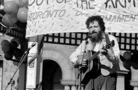[Musician playing guitar at Toronto Disarmament Network event]