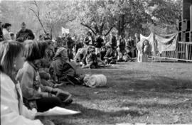 A group of people sitting on grass, looking at something to their right. TDN demonstration, Toron...