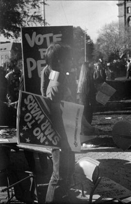 Person holding a "No To Star Wars" sign under their arm. Toronto, 1988.