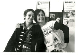 Photo of [Scamp?] and Lynn Kirk in front of a notice board