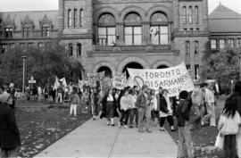Protesters walking and holding banners in front of the Ontario Legislative Building. Toronto, 1988.