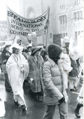 People carrying "Bread & Roses International Women's Day Committee," "Jobs for Women" and "Stop S...