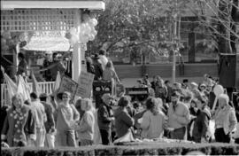 A crowd of people gathered around a gazebo at a TDN demonstration, holding  " Nuclear Free Canada...