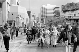 Protesters walking and holding signs in the street. Toronto, 1988.