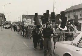 Side view of people marching and holding "Negotiate," "Unite and fight for women's rights" and "S...