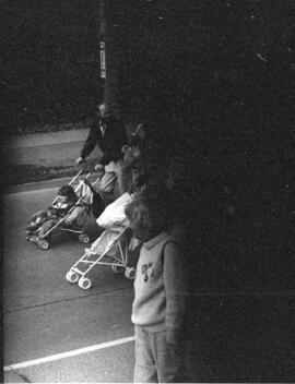 Group of people pushing strollers in the street. Toronto, 1988.