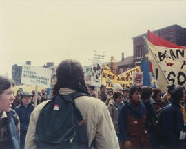International Women's Day march in Toronto back view of a person with braids and backpack