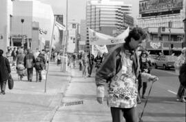 Protestor, with others behind him in the street with signs. Toronto, 1988.