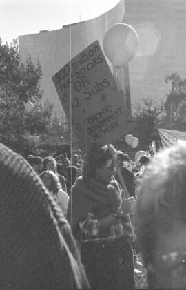 Person holding a sign in the middle of a crowd. Toronto, 1988.