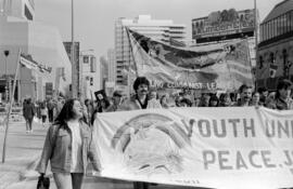 Protesters holding  "Youth Unite for Peace" banner in the street. Toronto, 1988.