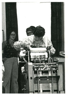 Amazon Print Shop interior view with Holly Devor (Aaron Devor) working on a press. Toronto