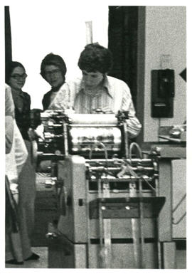 Amazon Print Shop interior view close up with Holly Devor (Aaron Devor) working on a press, Toronto